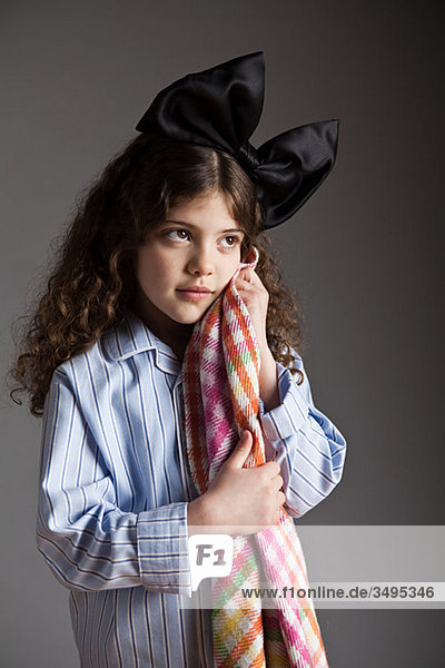 Junges Mädchen gekleidet in Pyjamas mit schwarzen Haaren Bogen  halten Komfort Decke