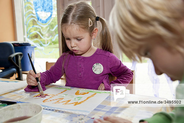 Mädchen und Junge malen im Kindergarten