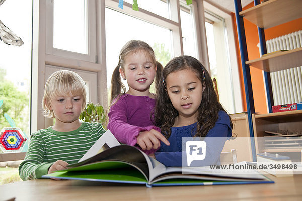 Kinder schauen sich ein Buch an  Flachwinkelansicht