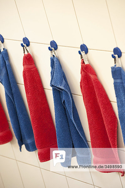 Handtücher hängen in einer Reihe an der Wand