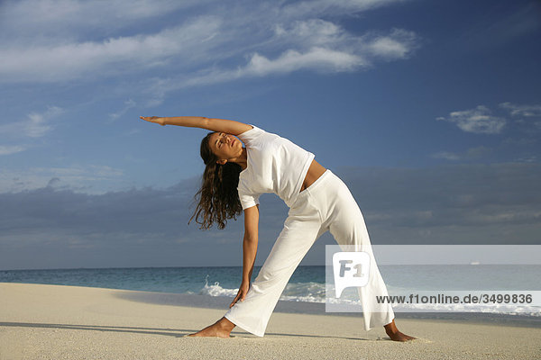 Young woman stretching at a beach  Paradise Island  Bahamas  low angle view