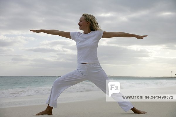 Frau praktiziert Yoga am Strand  Flachwinkelansicht
