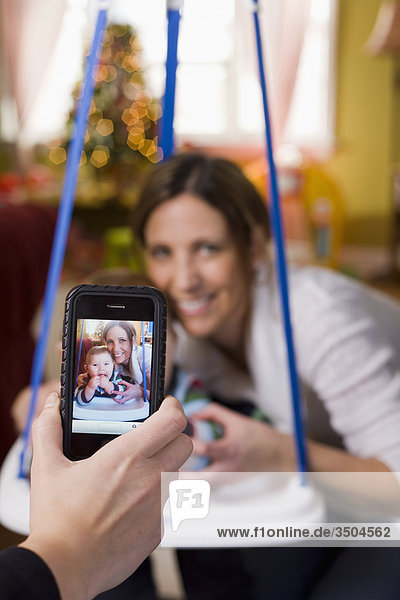 Frau nehmen Foto mit Smartphone von Freund und Baby zu Weihnachten  Bradford  Ontario