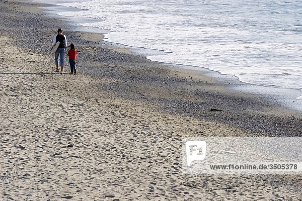 Mutter und Tochter hält hände und Wandern am Strand