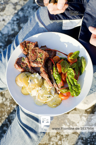 Gegrilltes Fleisch und Salat auf einer Platte  Schweden