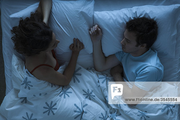 Paar liegt zusammen im Bett  Frau beobachtet Mann schlafend