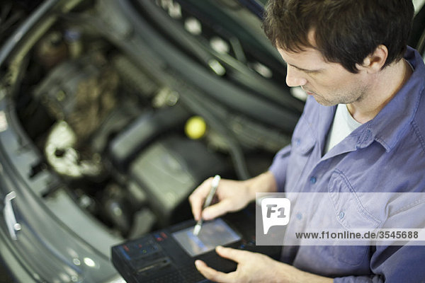 Mechanic using electronic tools to evaluate car performance