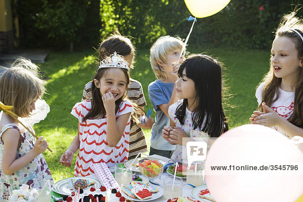 Kinder essen Süßigkeiten auf der Geburtstagsfeier