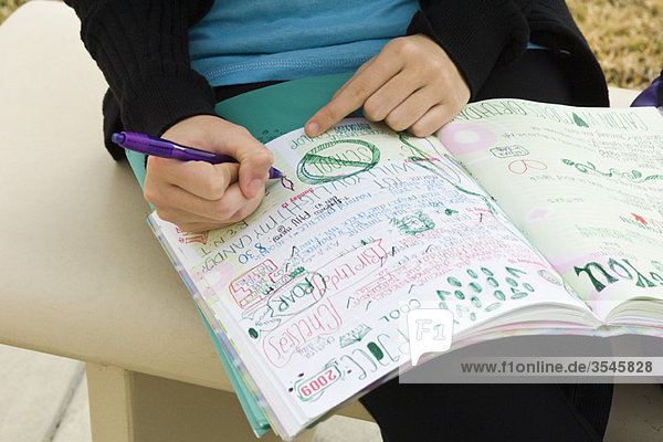 Schüler schreiben in einem Notizbuch  illustriert mit Kritzeleien