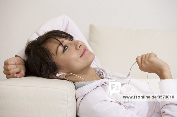 Happy woman in living room wearing headphones