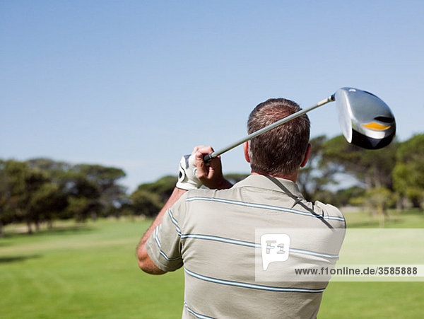 Mann spielt Golf auf dem Golfplatz