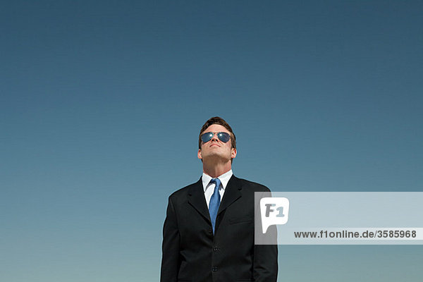 Geschäftsmann mit Sonnenbrille und Blick nach oben