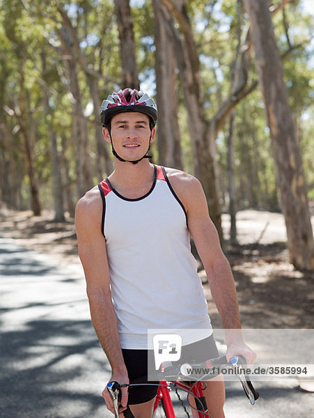 Young man cycling in forest