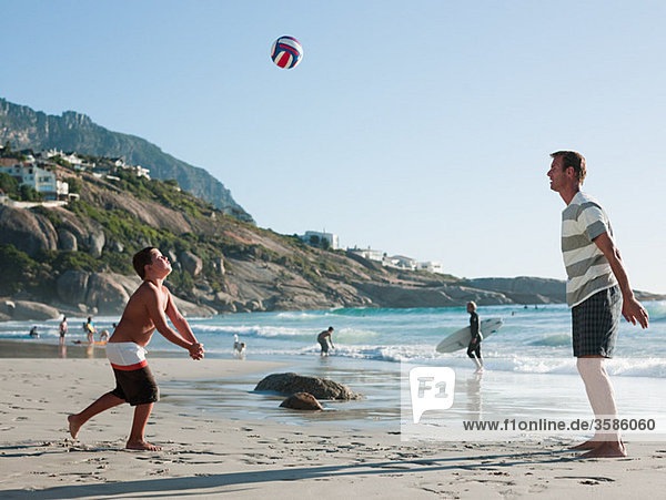 Vater und Sohn beim Ballspielen am Strand