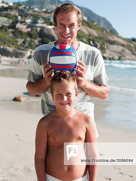 Father and son on a beach with ball