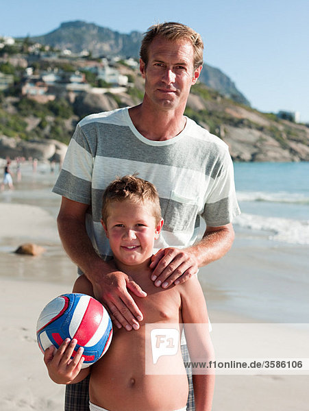 Father and son on beach with ball