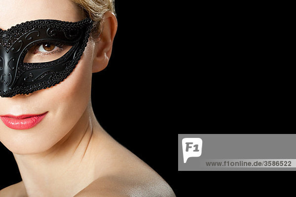 Junge blonde Frau mit schwarzer Maske