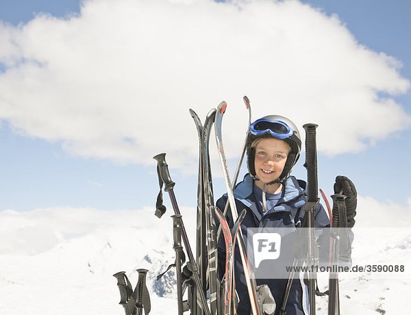 Junge mit Skiern in der Bergwelt