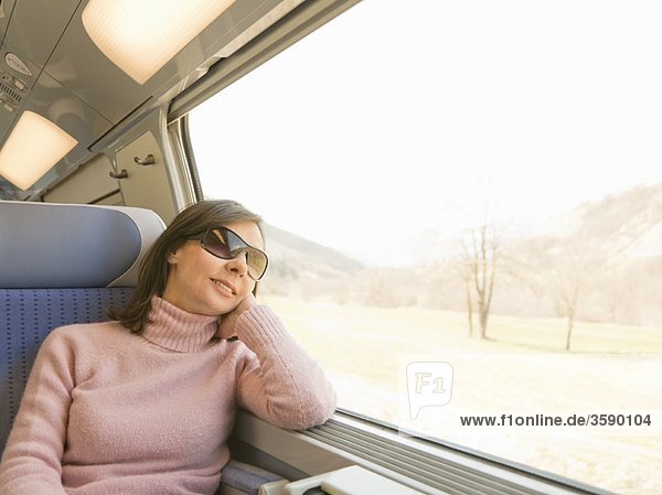 Frau die aus dem Fenster schaut im Zug