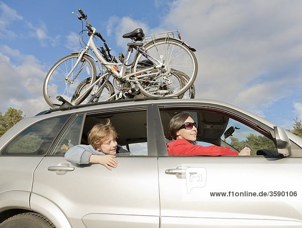 Woman & boy in car bikes on roof