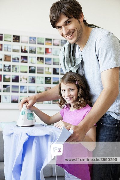 Father and daughter ironing