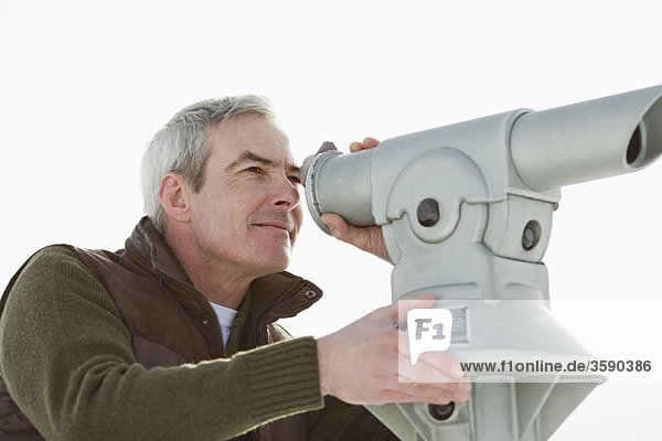 Mann schaut durch ein Teleskop