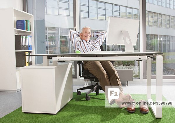Mann im Büro mit grünem Teppich