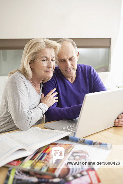 Couple looking at a laptop and smiling