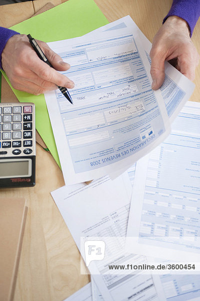 Man's hands filling his tax form