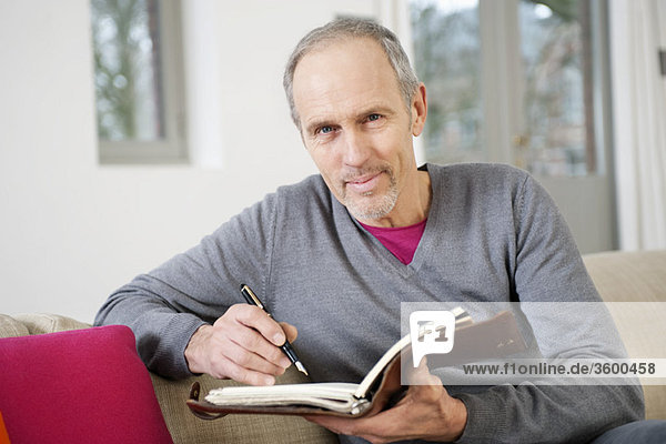 Man writing in a personal organizer