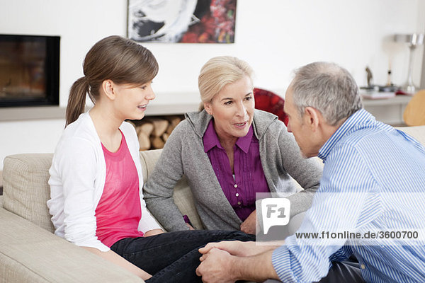 Mädchen sitzend mit ihren Großeltern