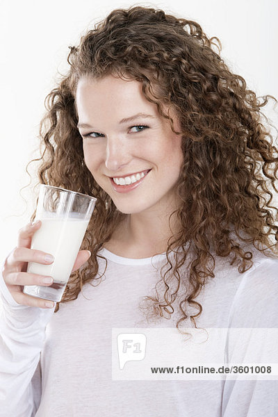 Portrait of a woman holding a glass of milk and smiling