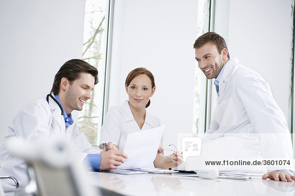 Three doctors examining a medical report
