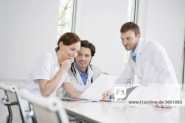 Drei Ärzte bei der Untersuchung eines medizinischen Gutachtens