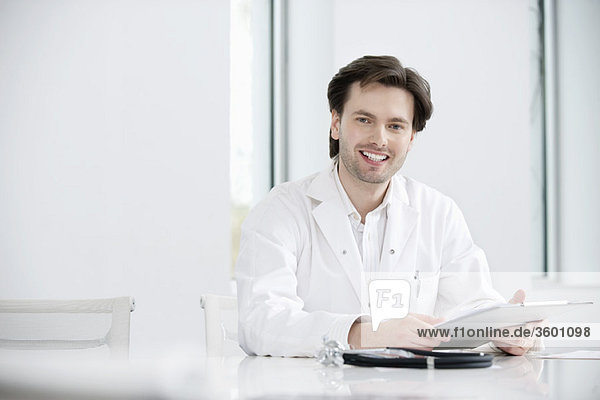 Male doctor holding a medical report and smiling