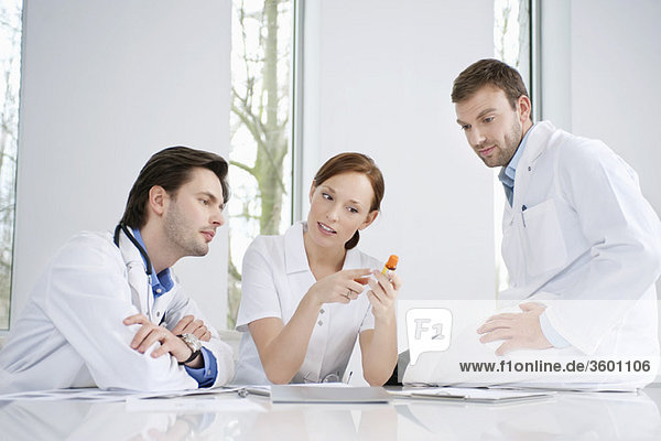 Three doctors examining medicine
