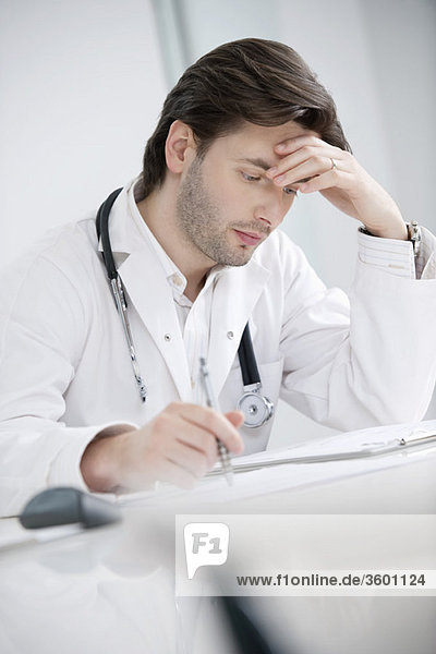 Male doctor sitting in his office and looking upset