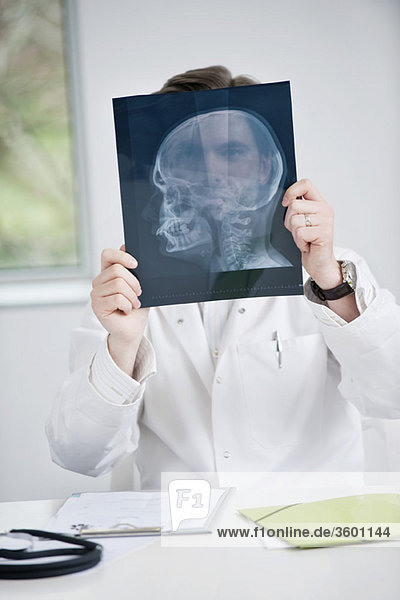 Männlicher Arzt bei der Untersuchung eines Röntgenbildes