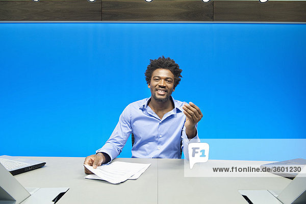 Businessman doing paperwork and smiling in a conference room