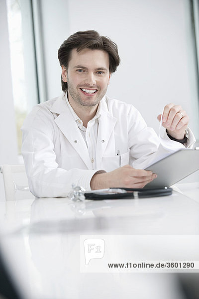 Male doctor holding a medical report and smiling