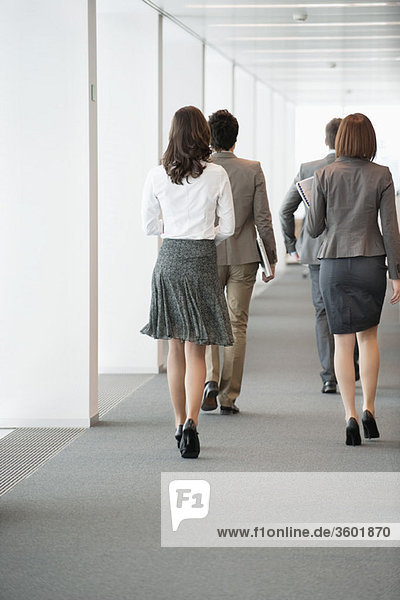 Geschäftsleute  die im Flur eines Büros spazieren gehen