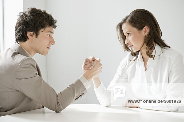 Businessman arm wrestling with a businesswoman