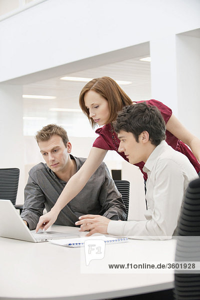 Businesswoman with two businessmen working in an office