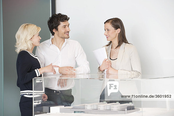 Man with two women near an architectural model