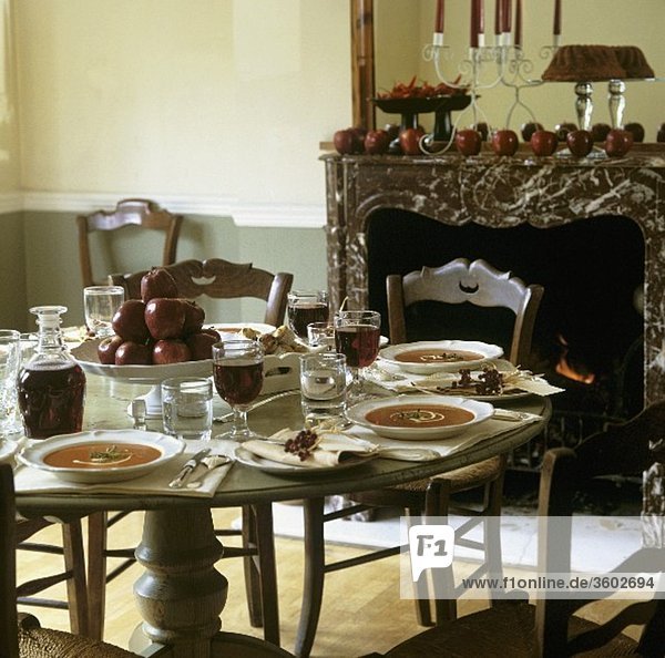 Herbstlich gedeckter Tisch mit Tomatensuppe  Äpfeln  Rotwein