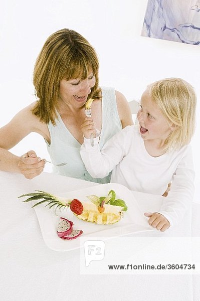 Mutter und Tochter essen Obst vom Obstteller