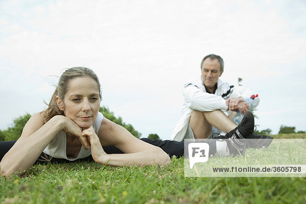 Mature couple stretching in park