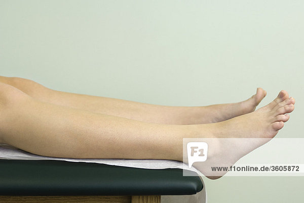 Patient on examination table preparing for exam  close-up of leg