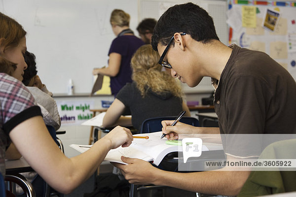 Gymnasiast hilft Klassenkameradin bei der Aufgabe