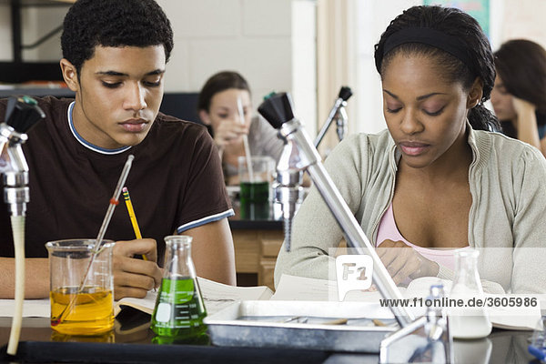 Studenten  die eine Arbeit im Chemieunterricht absolvieren